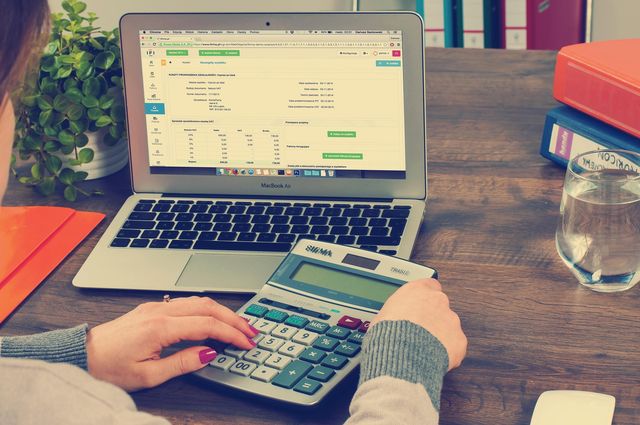 Accountant working on a laptop with a calculator